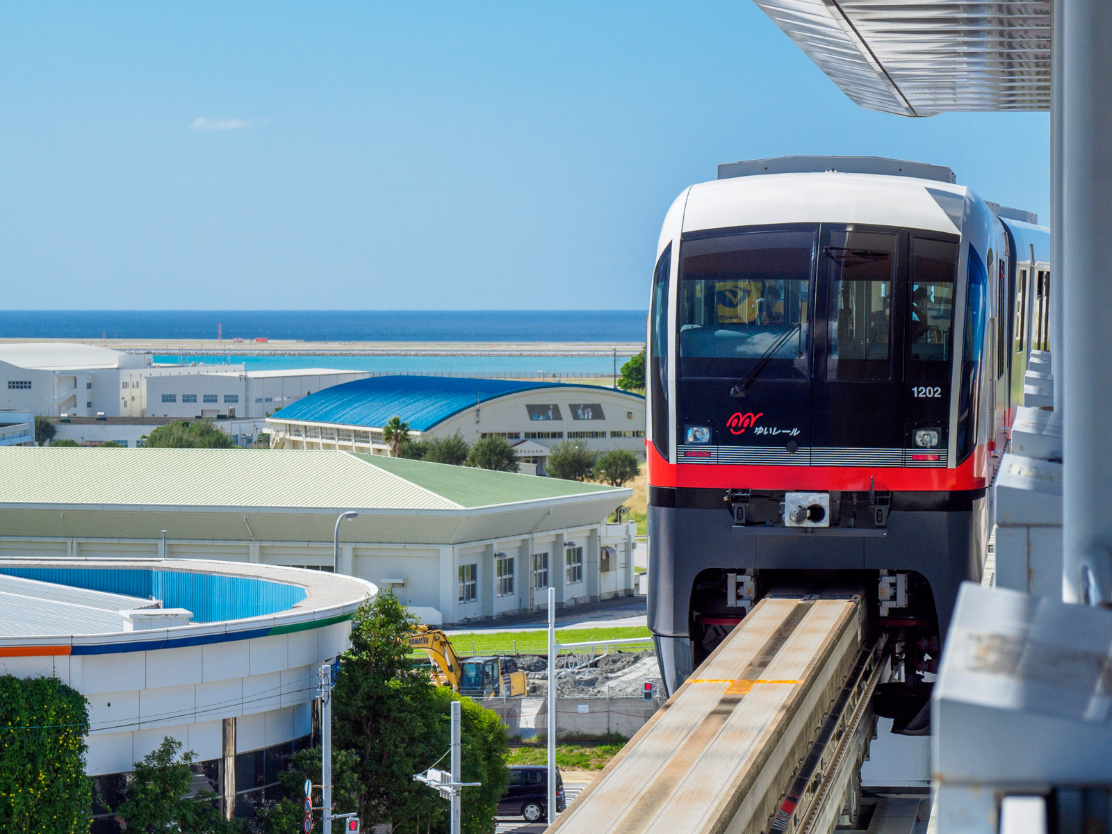 赤嶺駅を発つ列車と海、眼下の建物（2020年11月）