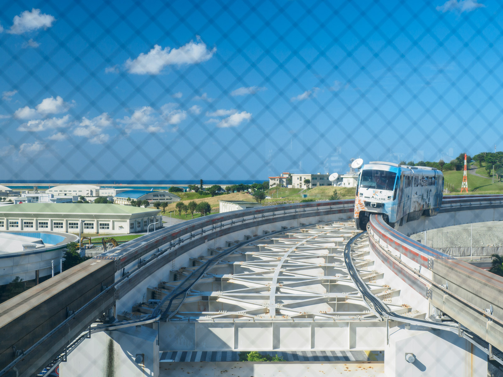 赤嶺駅のガラス越しに見た、海と到着する列車（2020年11月）