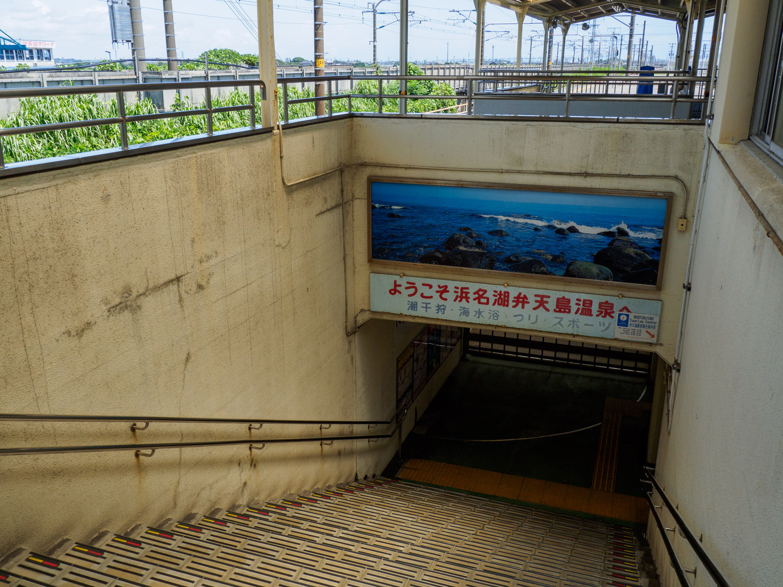 弁天島駅の階段にある「ようこそ浜名湖弁天島温泉へ」の看板（2022年7月）