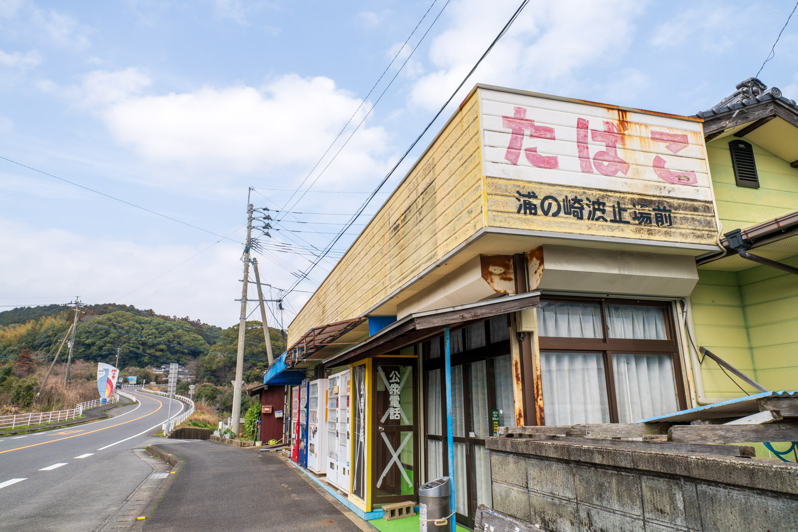 福島口駅近くの自販機が並ぶ商店の建物(2026年3月)