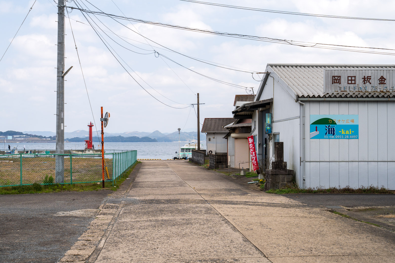 浦ノ崎港へ続く道と右手のカラオケ店(2026年3月)