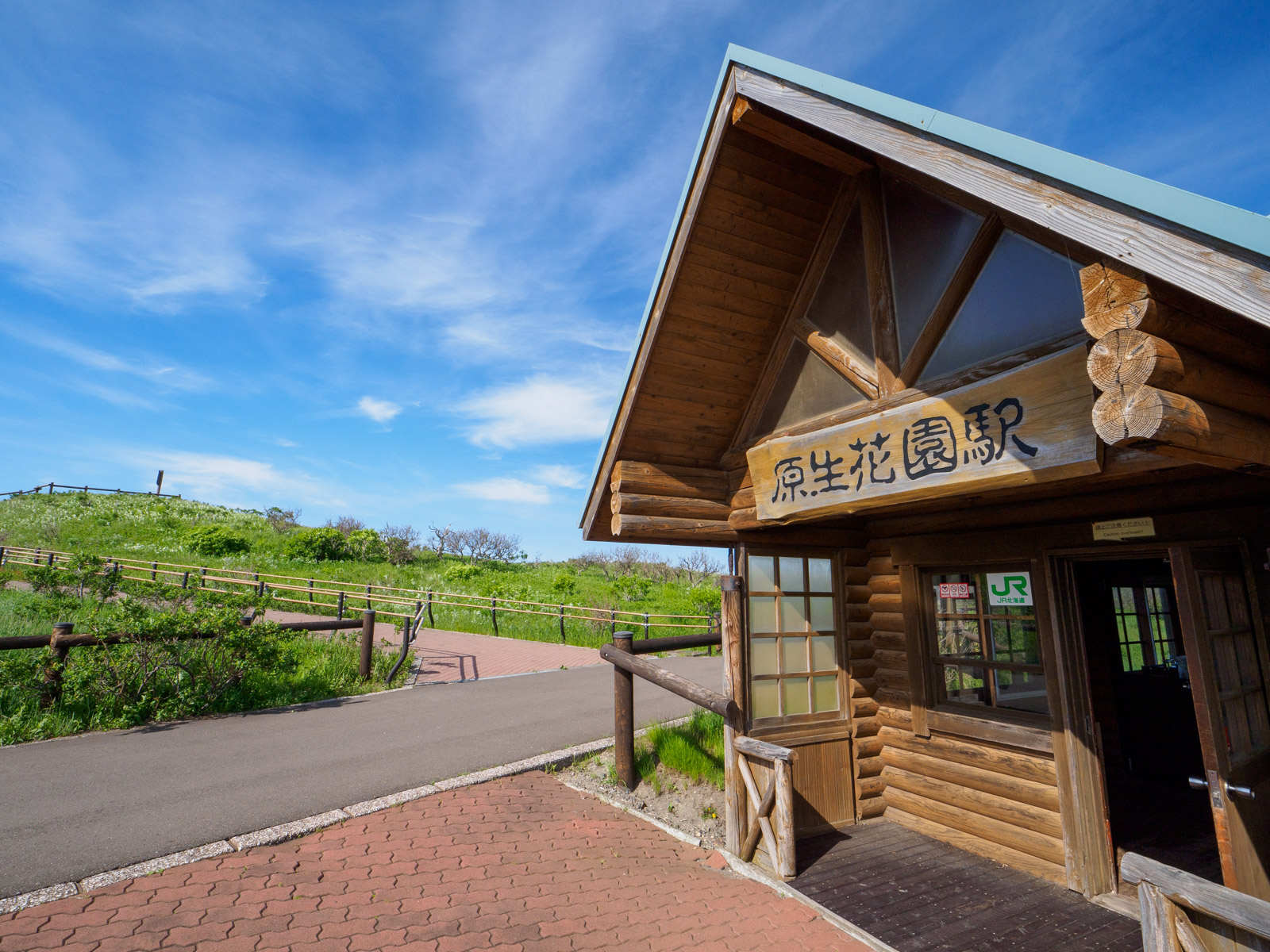 原生花園駅の駅舎と、小清水原生花園の天覧ヶ丘展望台（2024年6月）