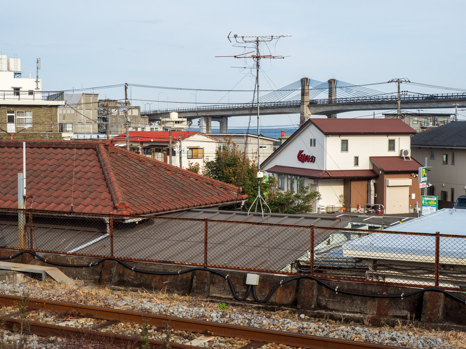 早川駅のホームから見た駅前風景、小田原ブルーウェイブリッジと相模湾(2024年2月)