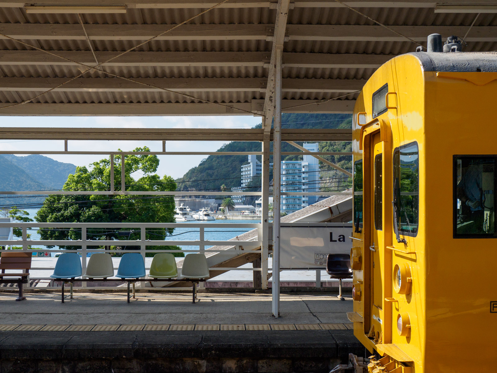 日生駅のホームに停まる列車と、日生港（2023年9月）