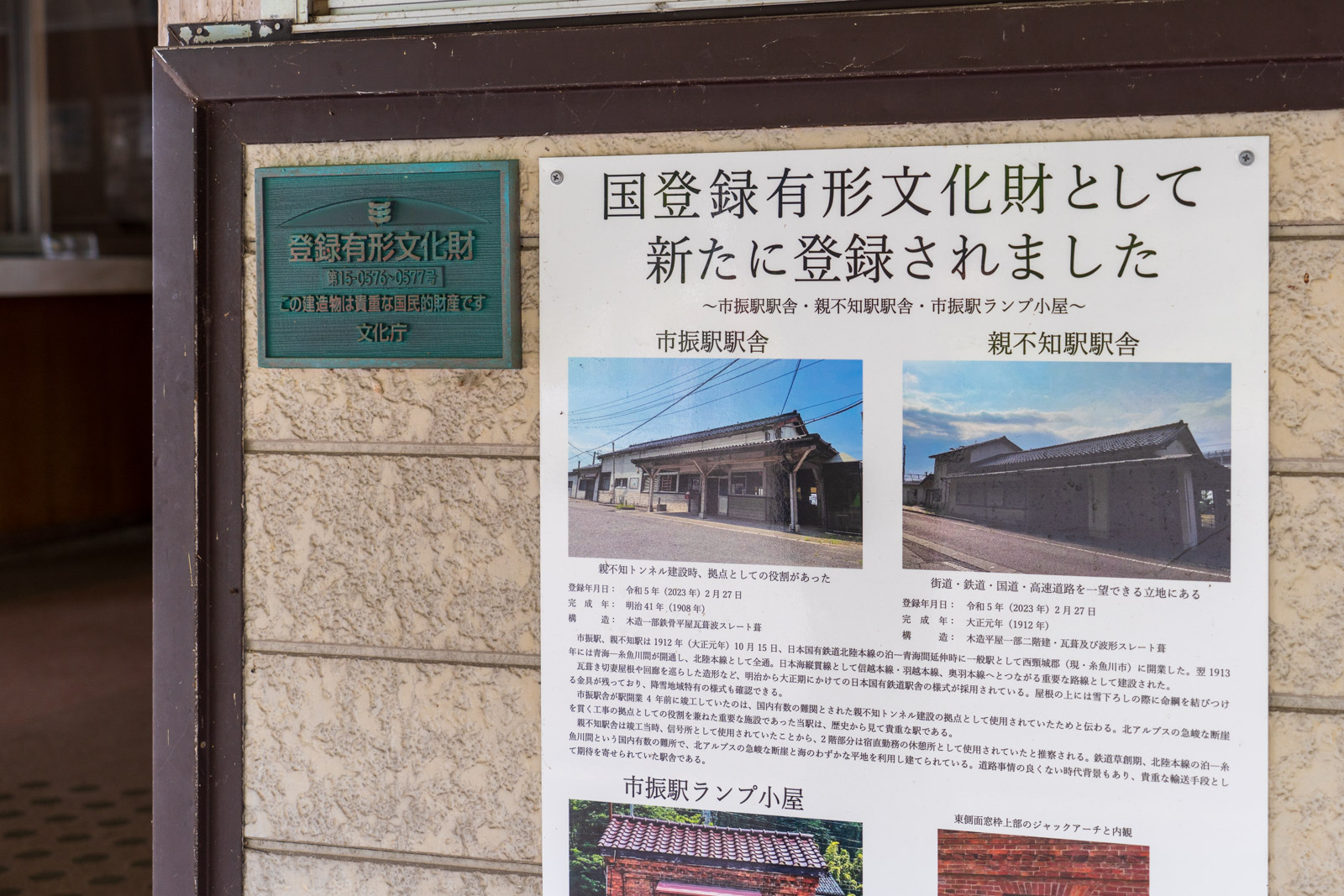 市振駅の木造駅舎にある、国登録有形文化財への登録を示すパネル(2026年6月)