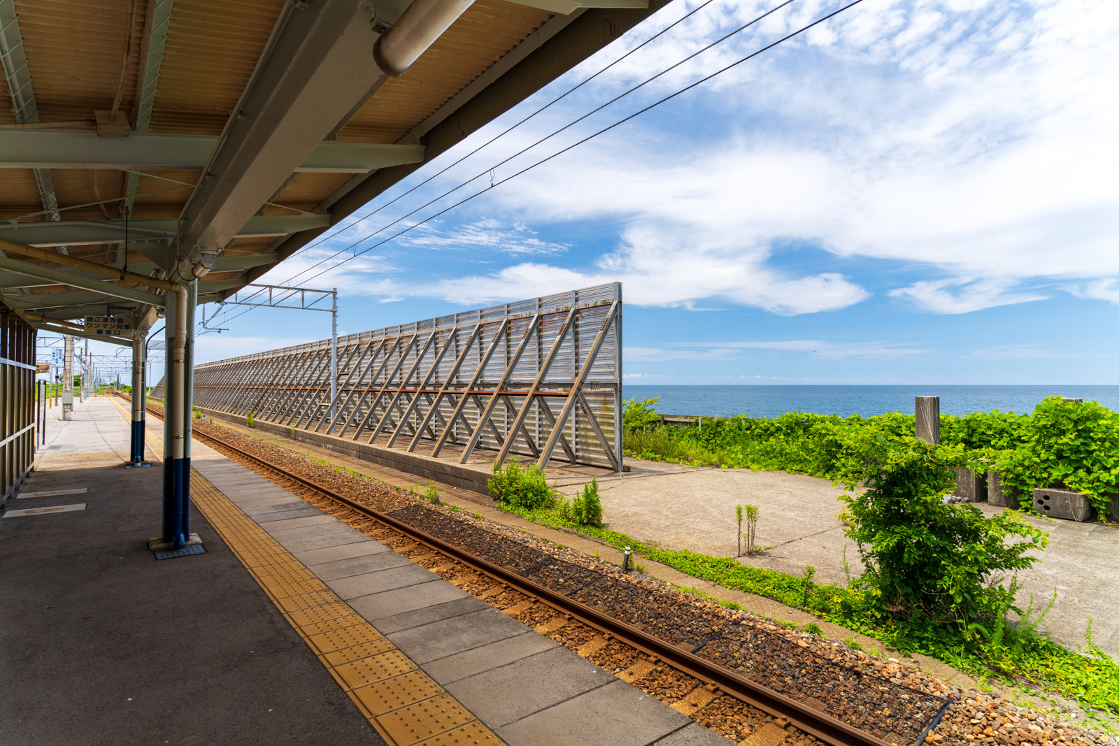 市振駅のホームにある波除けフェンスと、日本海(2026年6月)
