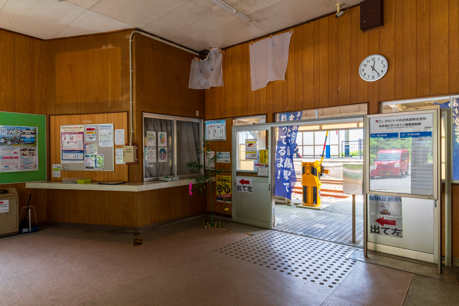 市振駅の駅舎と、掲げられた「ありがとう また、市振駅で待ってるよ!」の旗(2026年6月)