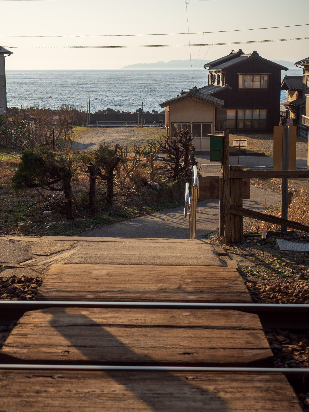 今川駅の構内踏切から見た、夕暮れの日本海と粟島(2016年3月)