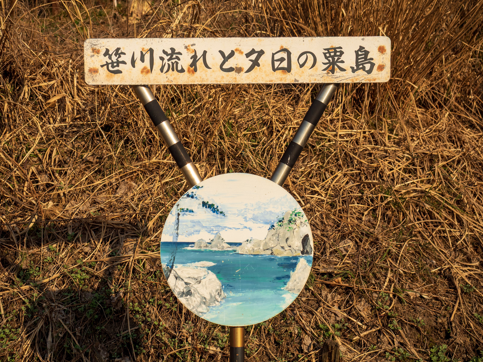 今川駅のホームにある「笹川流れと夕日の粟島」の看板(2016年3月)