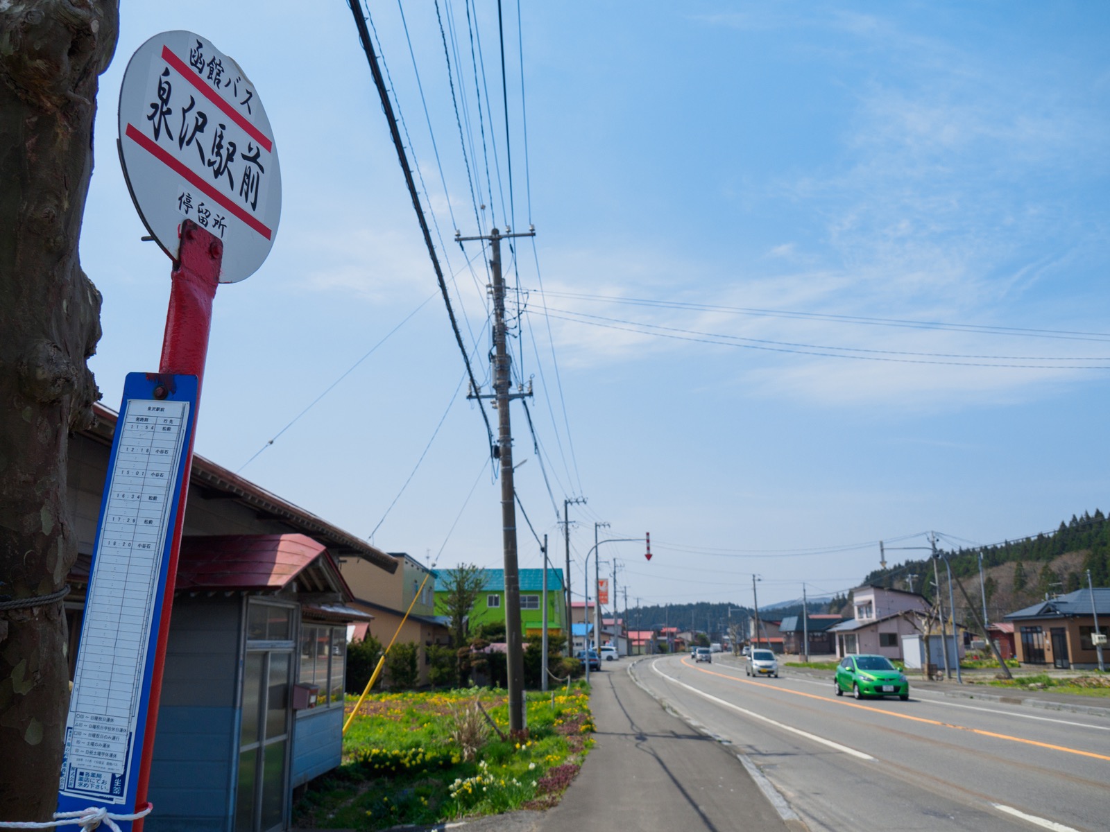 泉沢駅前を通る国道228号線と、函館バスの「泉沢駅前」バス停