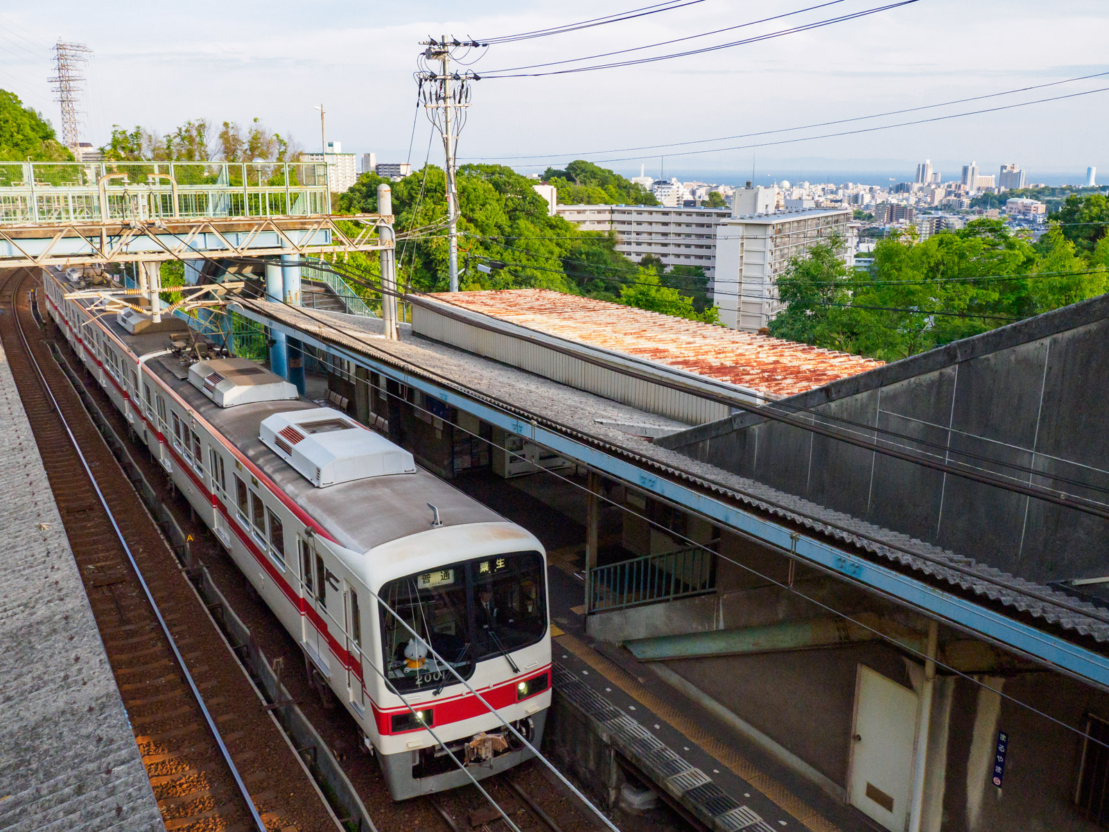 丸山駅の跨線橋から見たホーム、神戸の街並みと大阪湾（2022年5月）