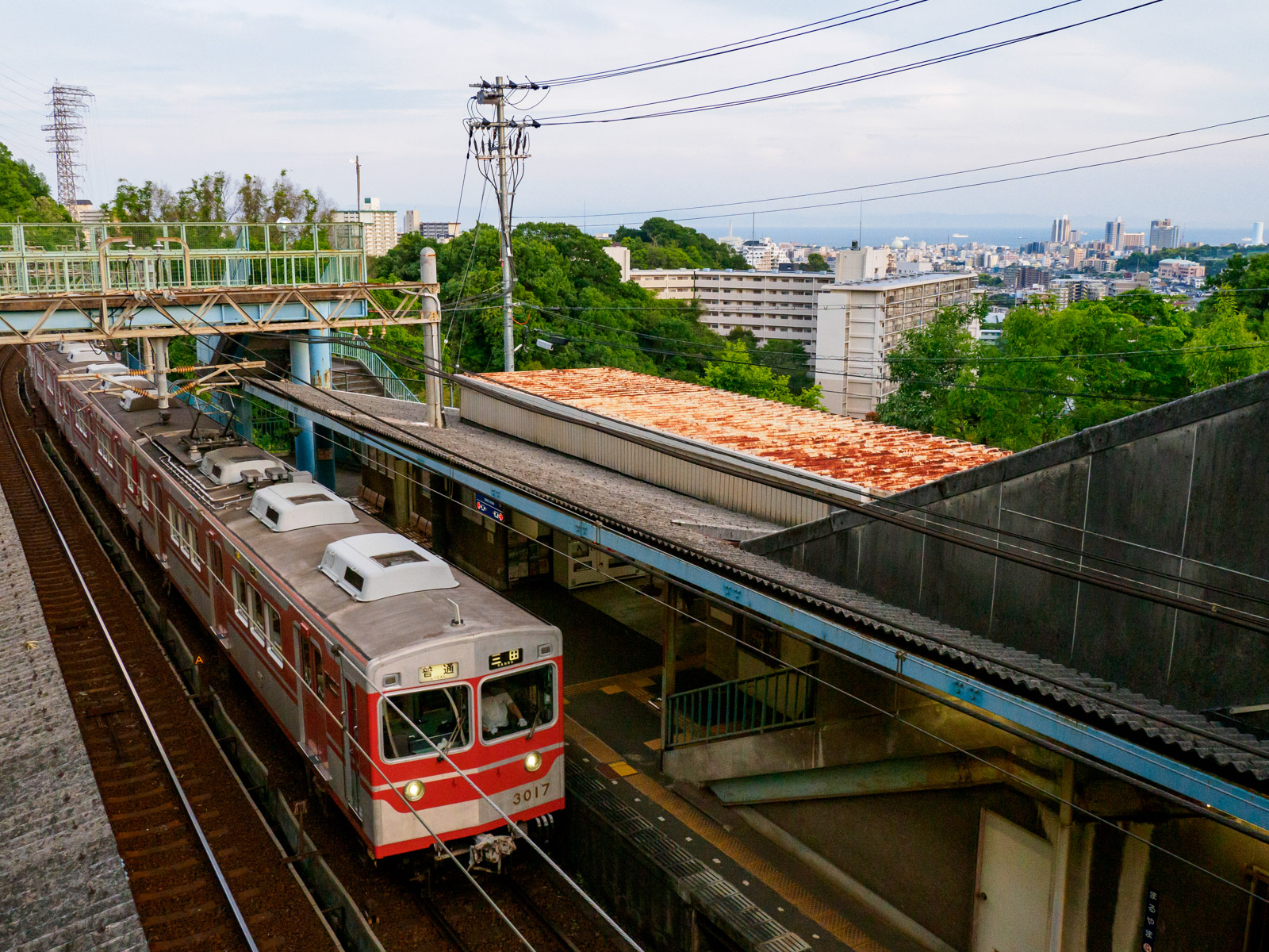 丸山駅の跨線橋から見たホーム、神戸の街並みと大阪湾（2022年5月）