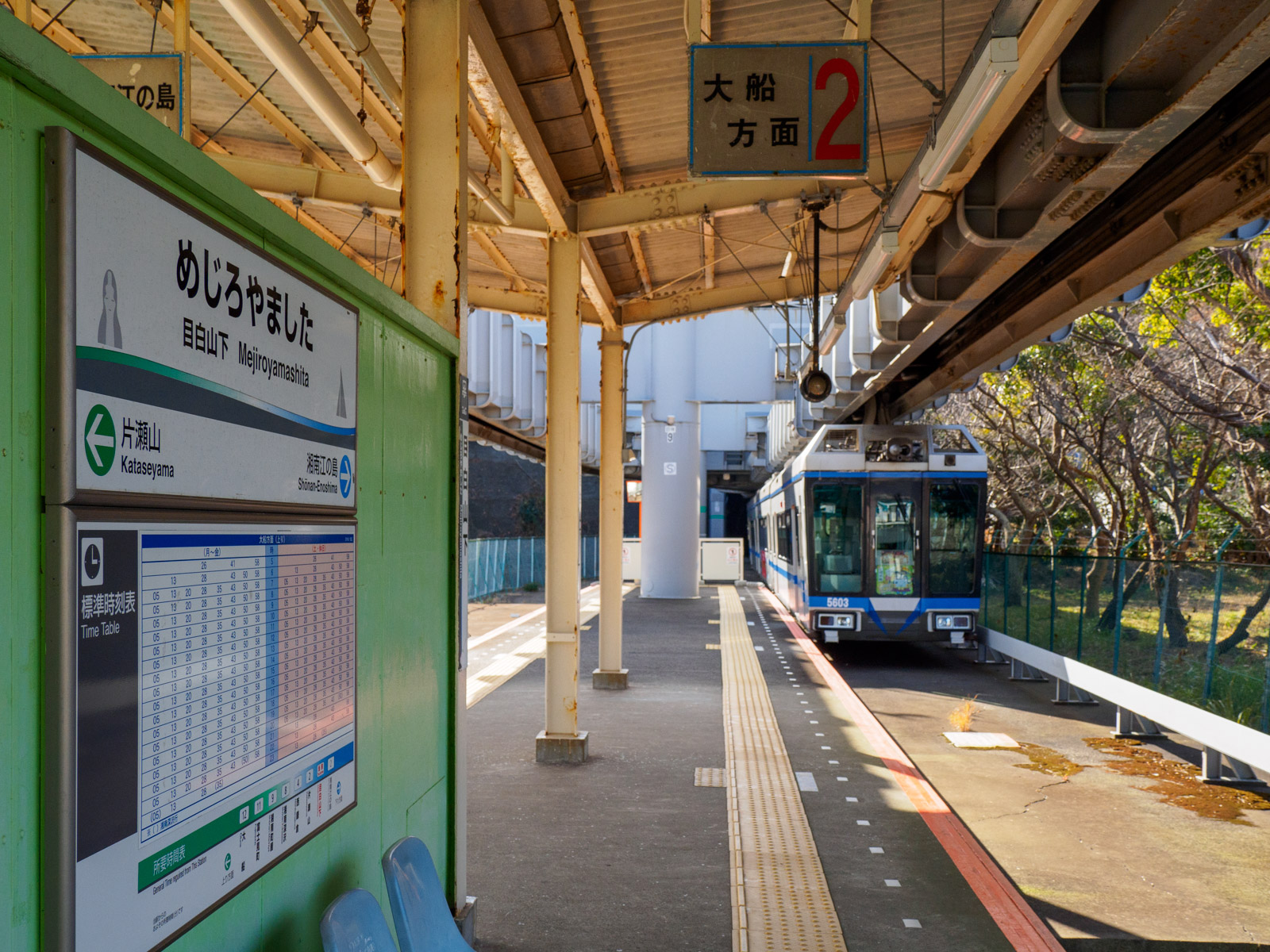 目白山下駅に到着した列車と、片瀬山公園の森（2022年1月）