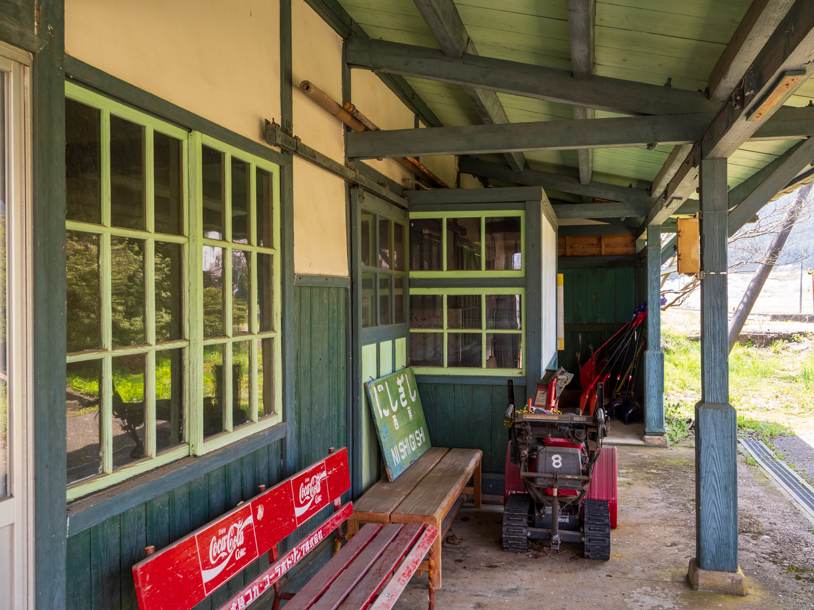 西岸駅の木造駅舎とベンチ、木製の駅名板(2025年4月)