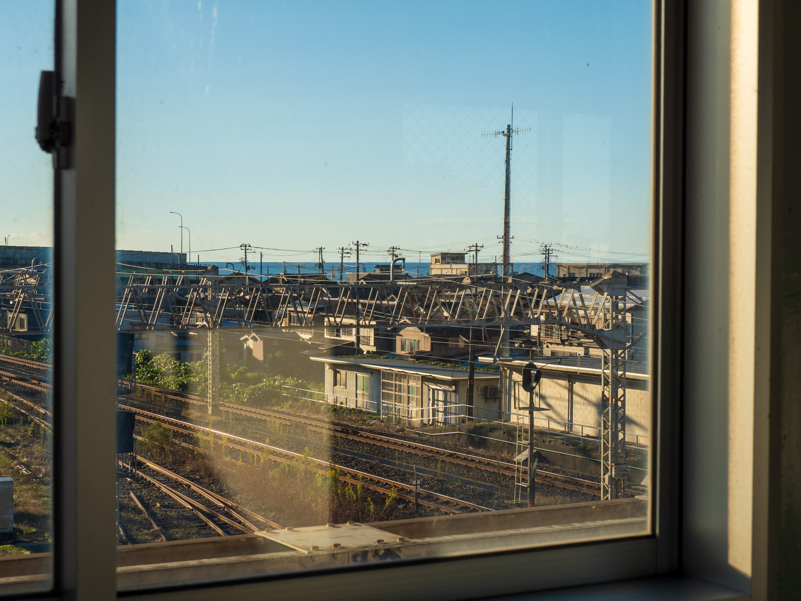 青海駅の自由通路の窓越しに見た、日本海と周辺の街並み(2022年10月)
