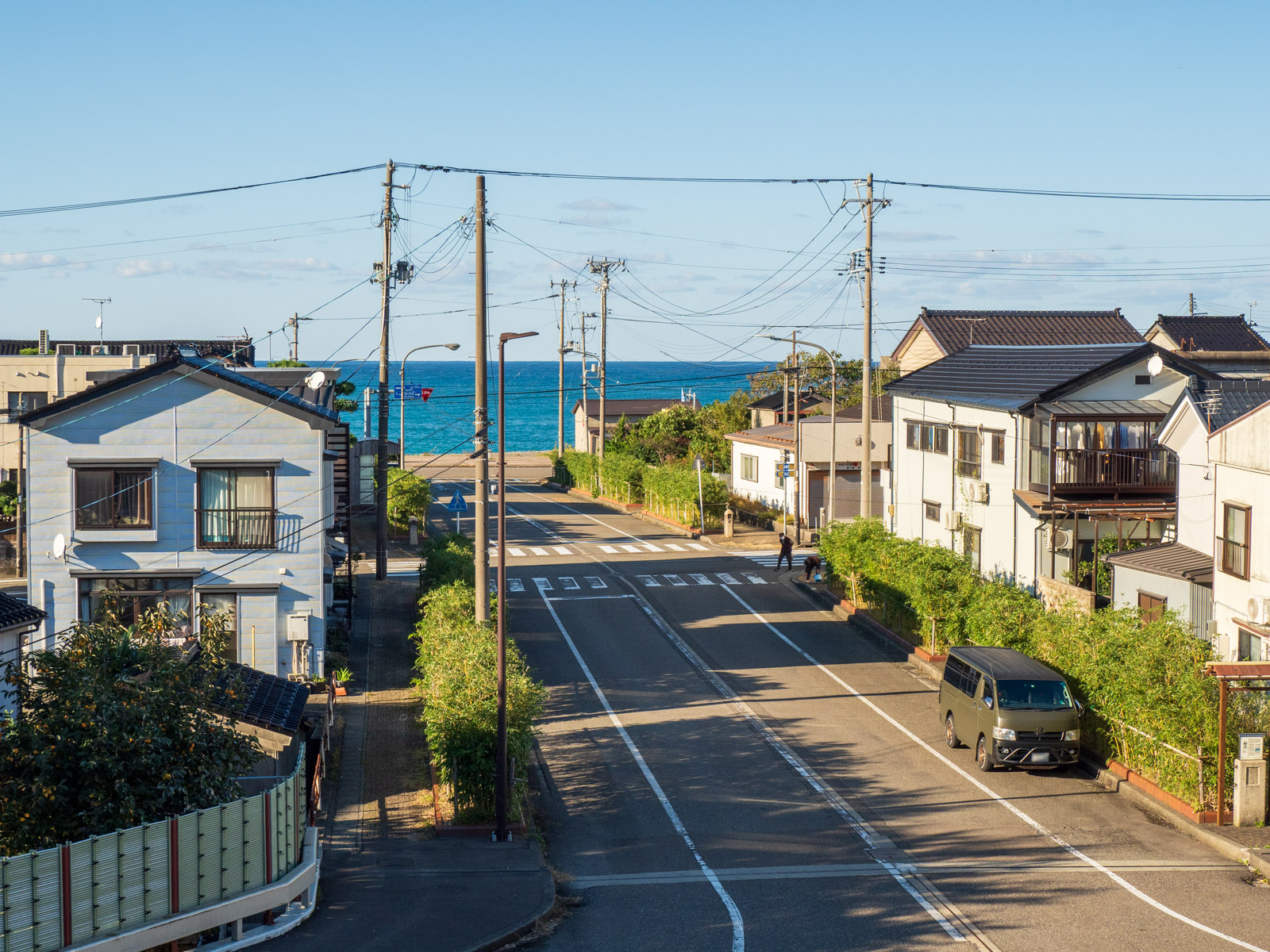 青海駅の自由通路の窓越しに見た、駅前と日本海(2022年10月)