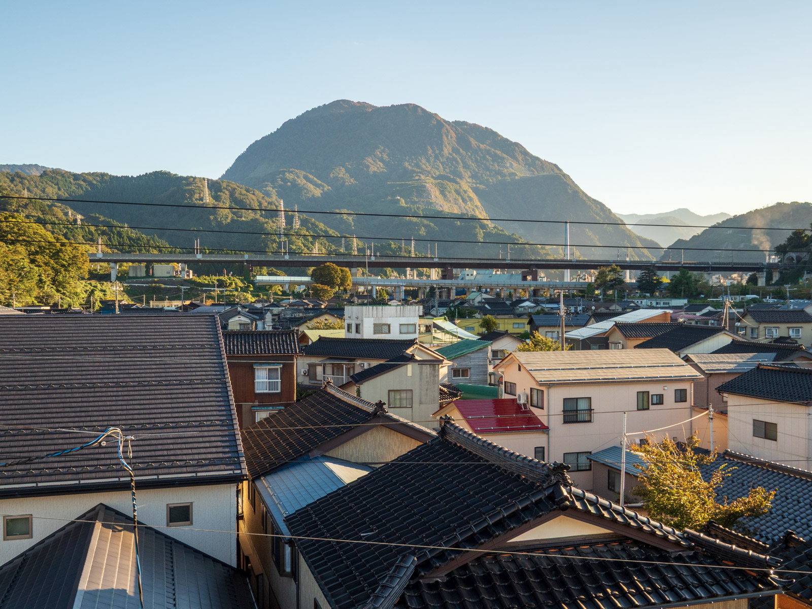 青海駅の自由通路から見た、黒姫山と北陸自動車道・北陸新幹線の高架橋、駅前に広がる住宅地(2022年10月)