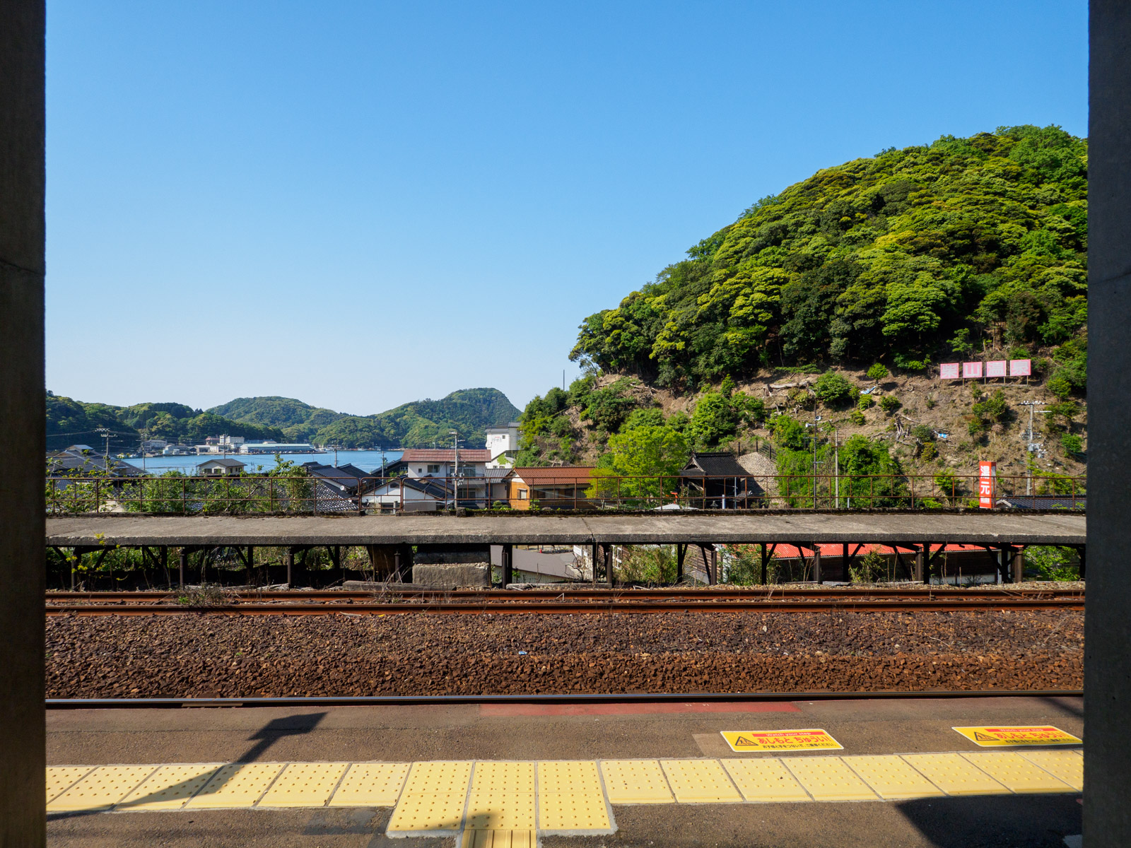 柴山駅から見た、柴山港と「柴山温泉」の看板木造駅舎があった頃の柴山駅のホーム（2016年10月）