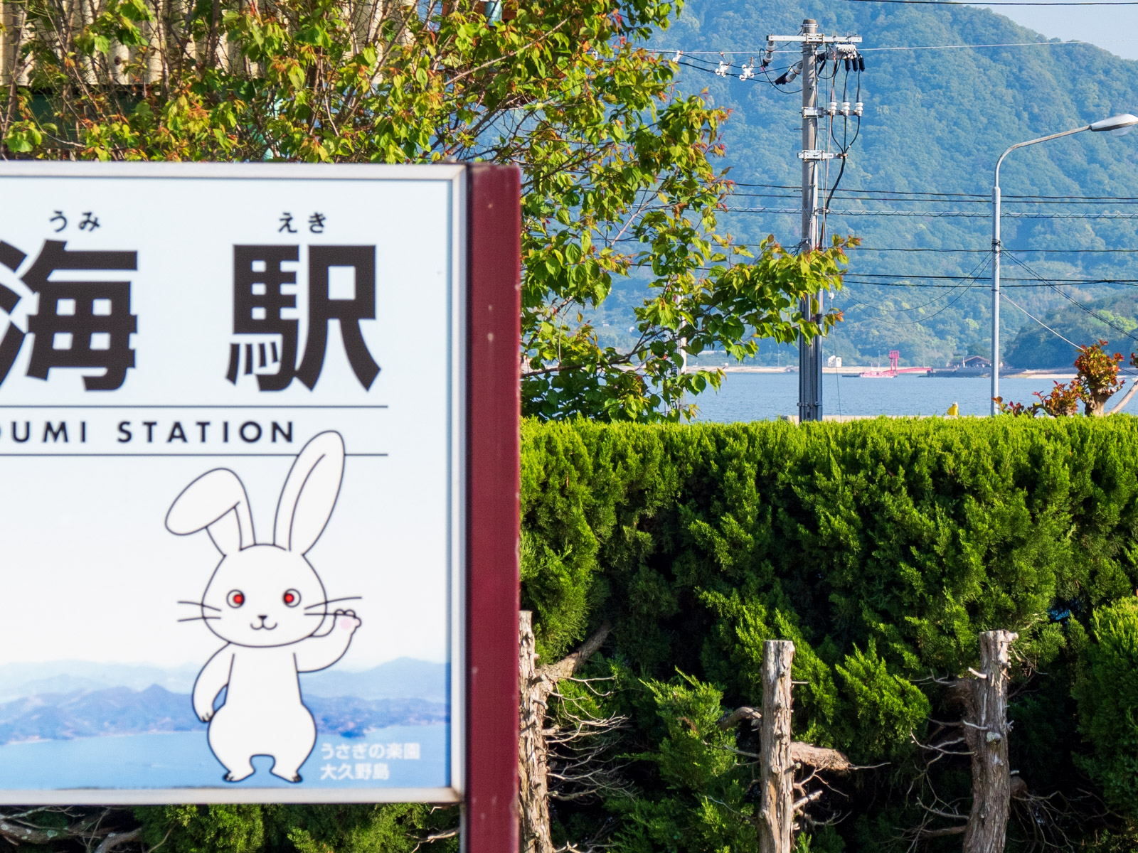忠海駅の駅名標越しに見た、大久野島の桟橋（2023年5月）