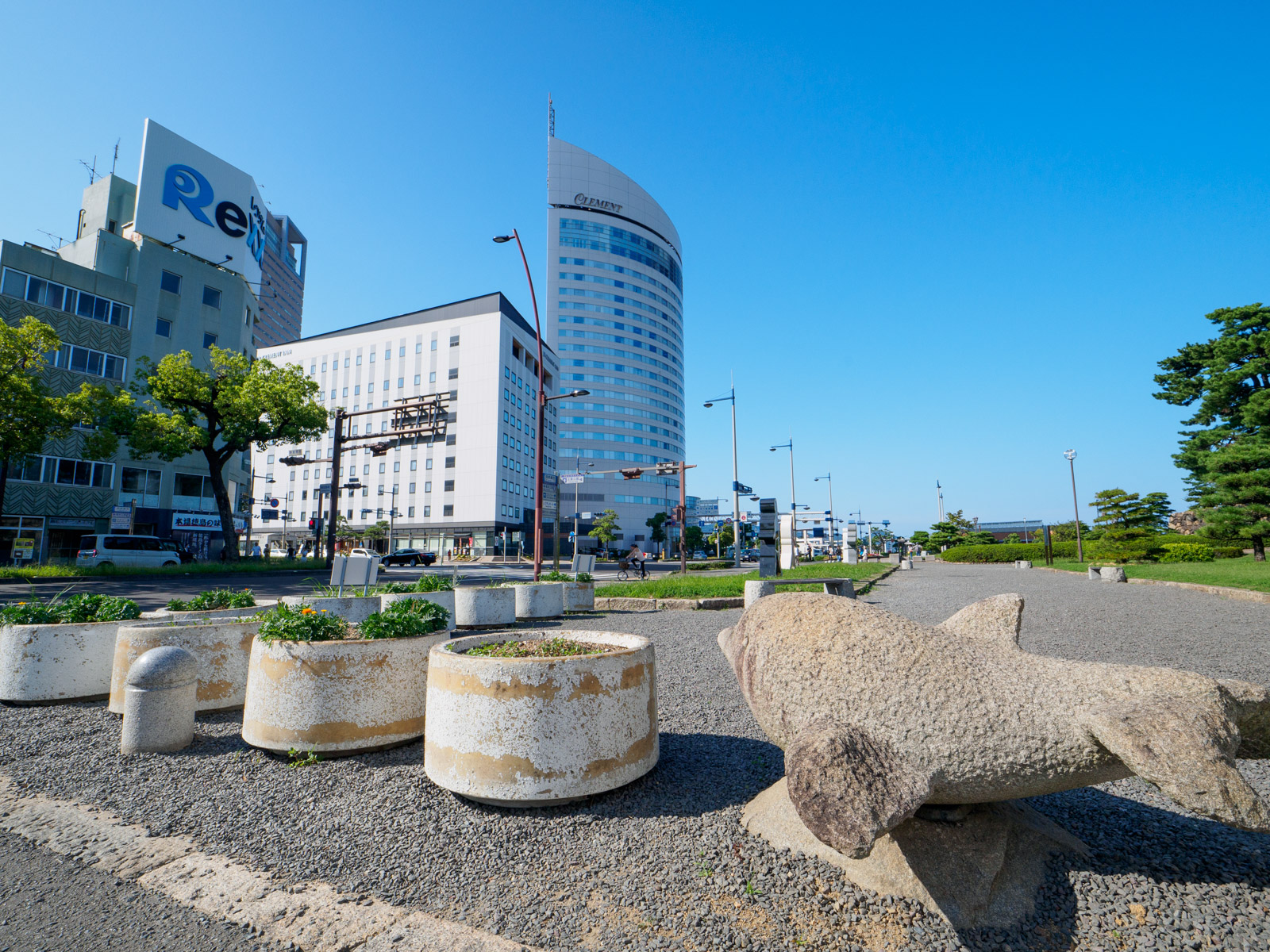 高松築港駅前のビル群とイルカの石像（2023年9月）