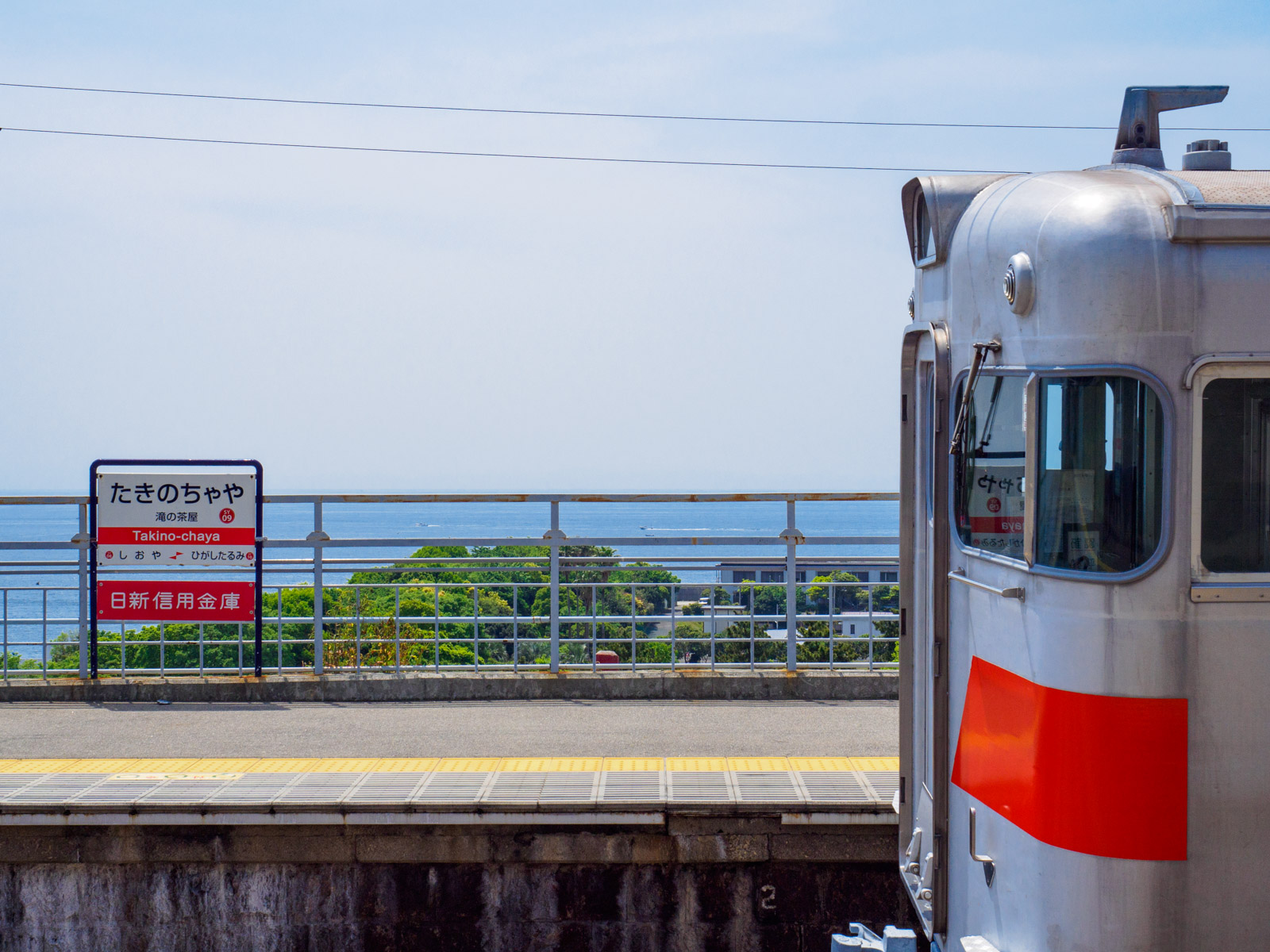 滝の茶屋駅のホームを発つ列車と瀬戸内海（2017年5月）