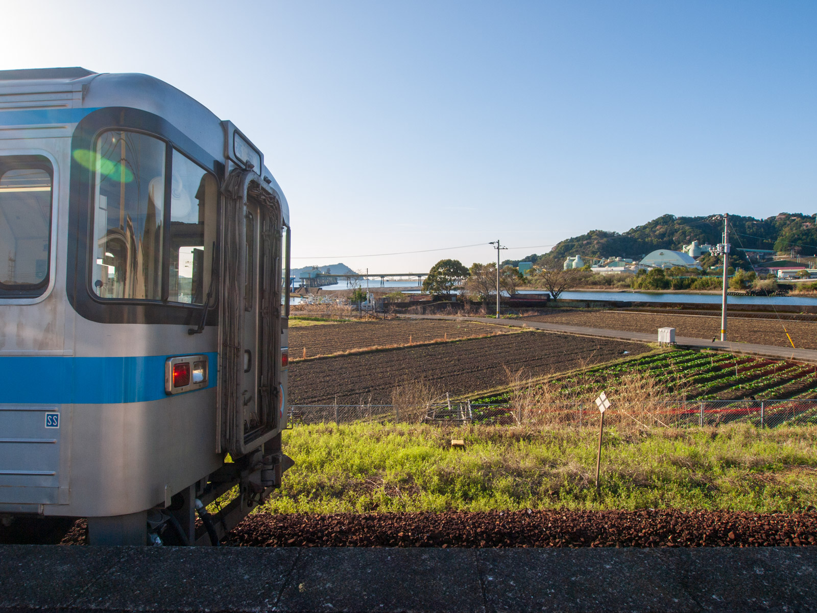 土佐新荘駅のホームに到着した列車と、須崎湾（2013年3月）