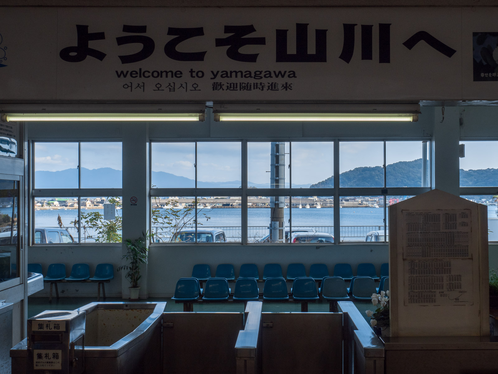 山川駅の改札口と、駅舎の窓越しの山川湾（2016年2月）