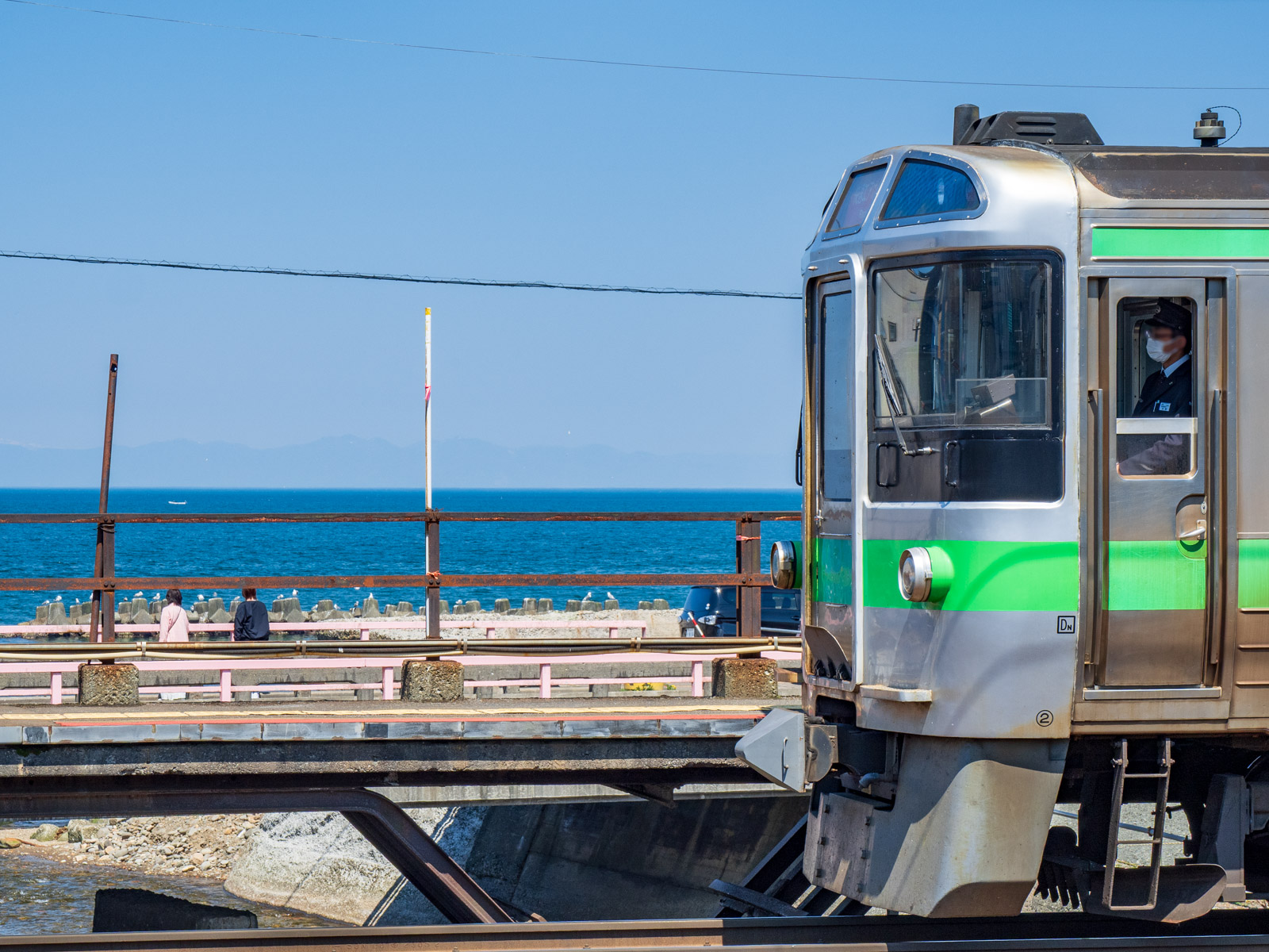 銭函駅のホームと列車と石狩湾（2024年5月）